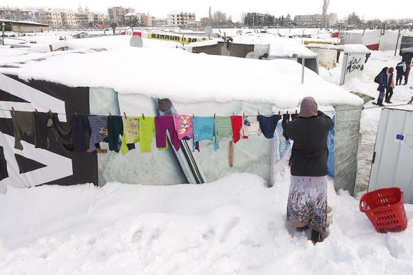 A Syrian woman hangs her laundry at a refugee camp in Zahleh in Lebanon