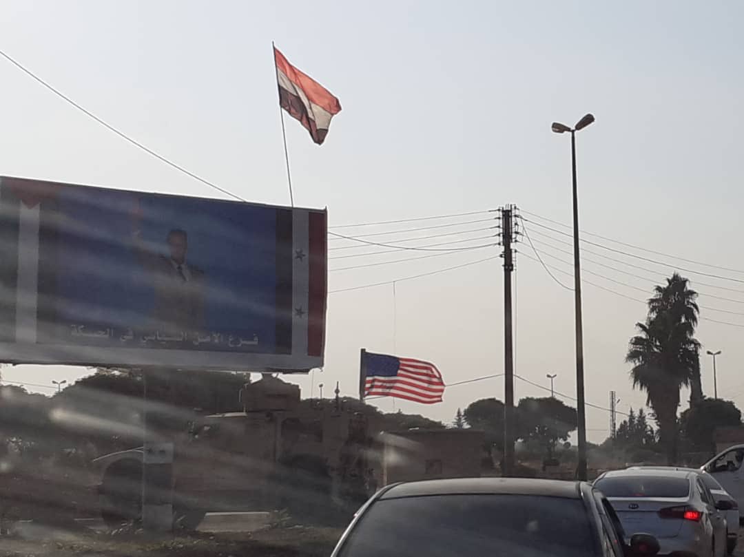 US military vehicle passes under Assad's picture in Qamishli. A Russian military police convoy passed by earlier today