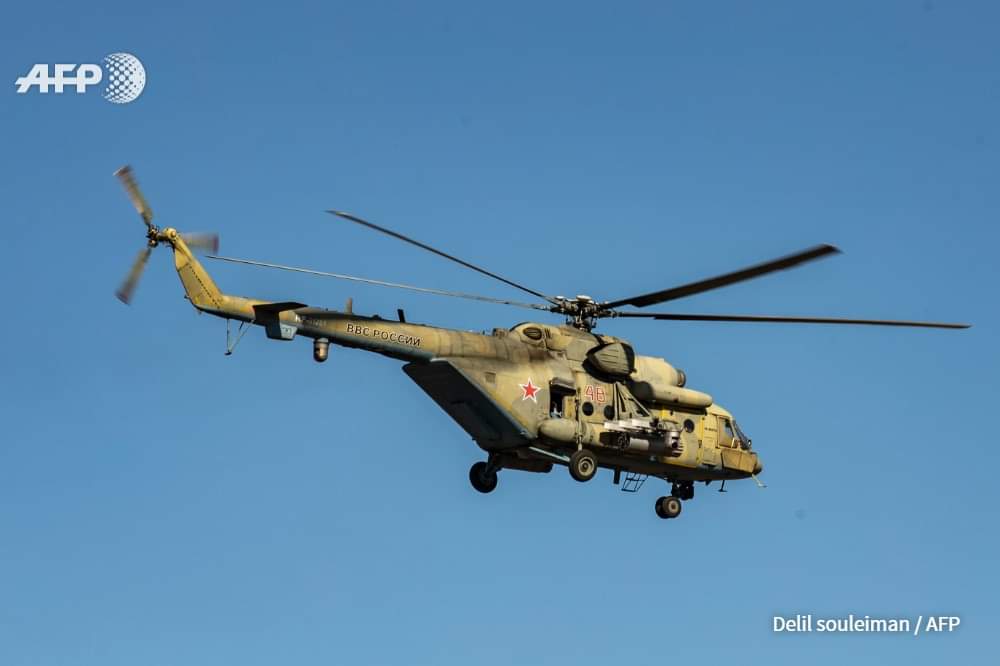 A Russian army helicopter flies over a patrol of US soldiers in the town of Tal Tamr in the northeastern Syrian Hasakeh province on the border with Turkey on January 26, 2020. Delil SOULEIMAN / AFP