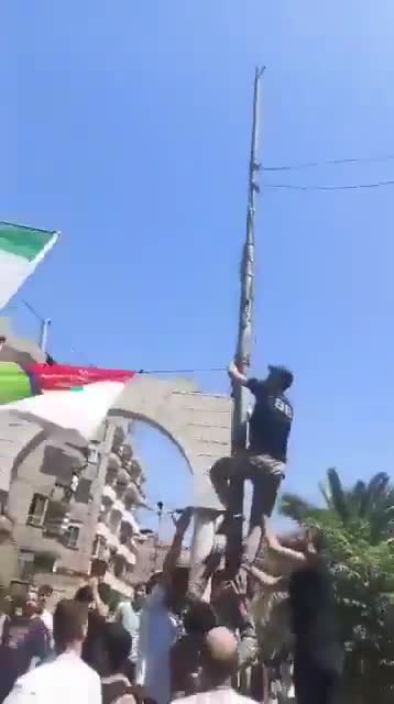 In Jarmana near Damascus, the new Syrian flag is being removed