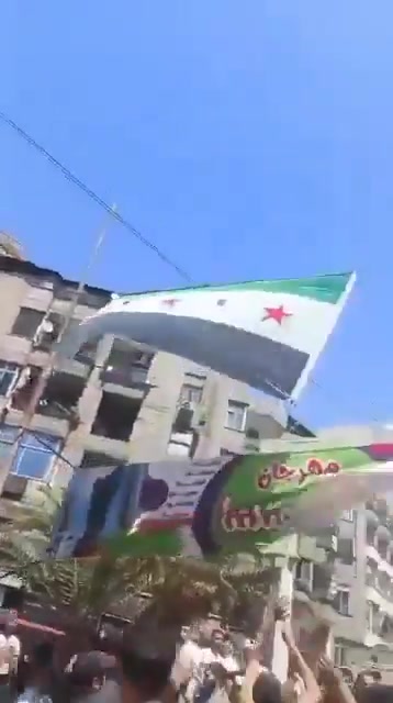In Jarmana near Damascus, the new Syrian flag is being removed