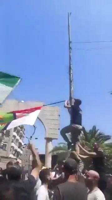 In Jarmana near Damascus, the new Syrian flag is being removed