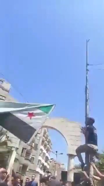 In Jarmana near Damascus, the new Syrian flag is being removed
