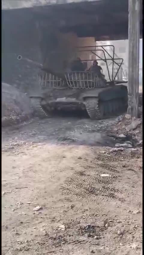 Syria: a tank photographed while targeting an Asayish position near Sheikh Maqsoud in Aleppo. For the first time, Government's tanks are equipped with an anti-drone cage.